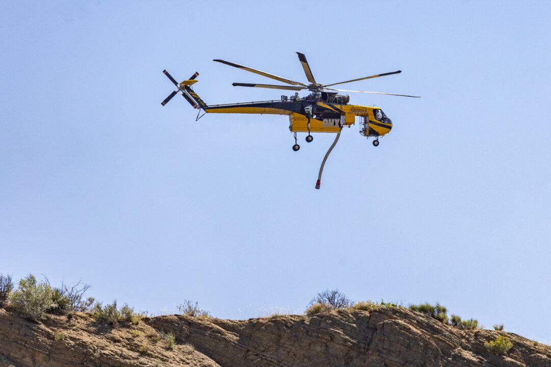 A firefighting helicopter works to clear the post fire burning outside of Gorman, Calif., on June 17, 2024. (John Fredricks/The Epoch Times)