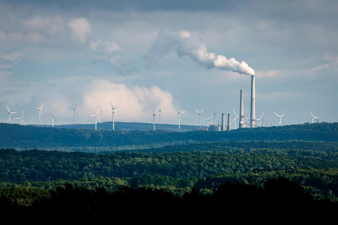 Turbines from the Mount Storm Wind Farm sit behind the Dominion's Mount Storm Power Station in Mount Storm, W. Va., on Aug. 22, 2022. A survey of Americans shows that 72 percent of respondents favor expanding wind power. (Chip Somodevilla/Getty Images)