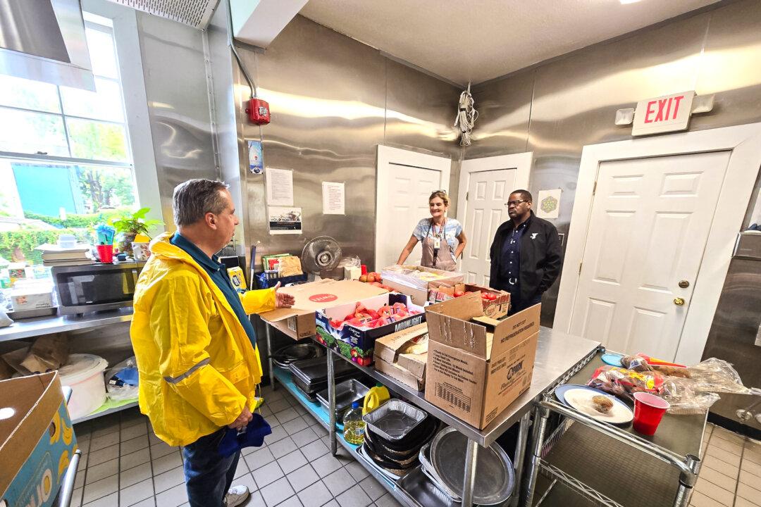 Greg Loeb (L), managing director of food services, coordinates food preparation with St. Joseph Director Darrien Phillips (R), and volunteer Loretta Scribner, at Magnificat Houses in Houston on July 26, 2024. (Allan Stein/The Epoch Times)