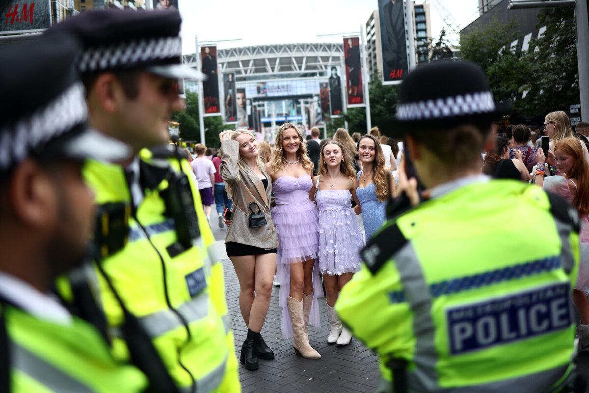 A police officer takes a photograph of fans of U.S. megastar Taylor Swift as they gather on Olympic Way outside Wembley Stadium in London on Aug. 15, 2024, ahead of the first of five concerts at the stadium. Swift returned to the stage in London to end the European leg of her "Eras" tour, a week after her Vienna concerts were canceled because of a suicide attack plot. (Henry Nicholls/AFP via Getty Images)