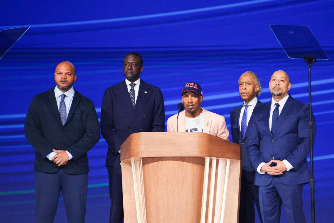 Activist Korey Wise (C) speaks on stage as representatives from “the Central Park Five,” (L-R) Activist Kevin Richardson, New York City Council Member Dr. Yusef Salaam, and Activist Raymond Santana, along with Rev. Al Sharpton (2nd-R) look on during the last day of the Democratic National Convention in Chicago on Aug. 22, 2024. (Madalina Vasiliu/The Epoch Times)