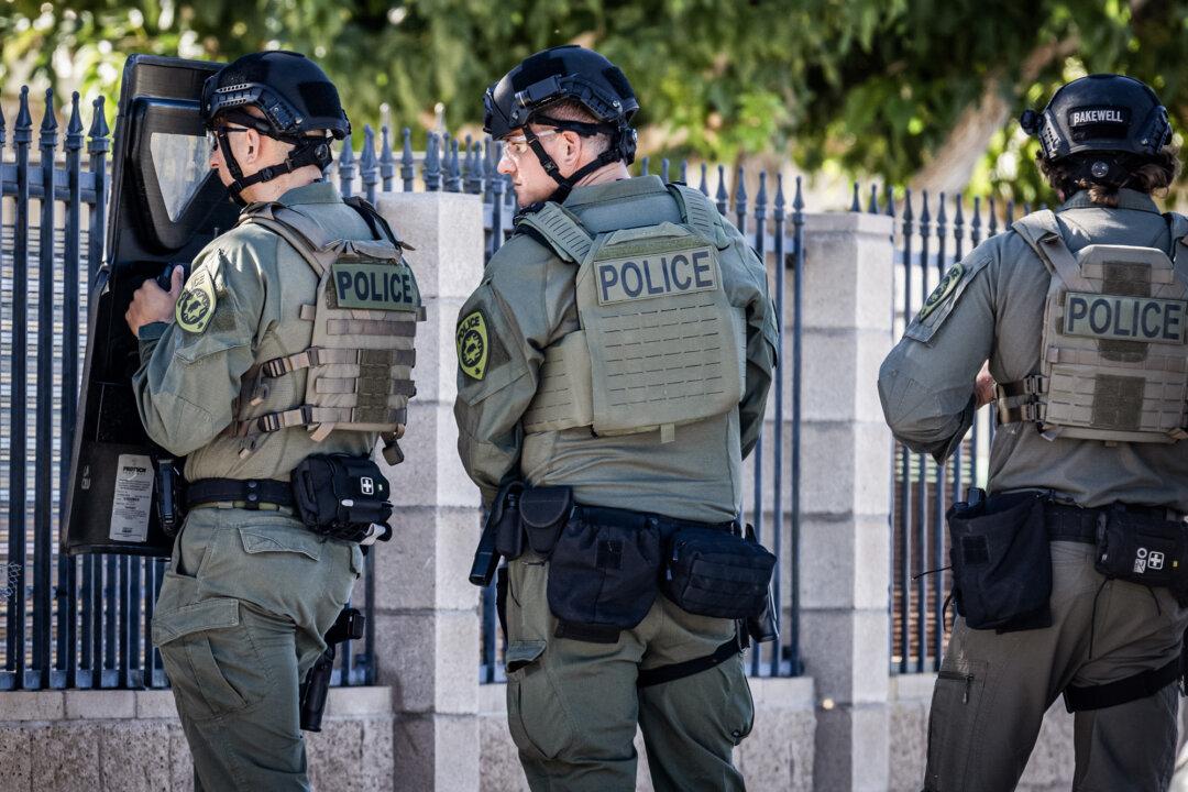 Police officers guard the outside of an illegal marijuana home. (John Fredricks/The Epoch Times)