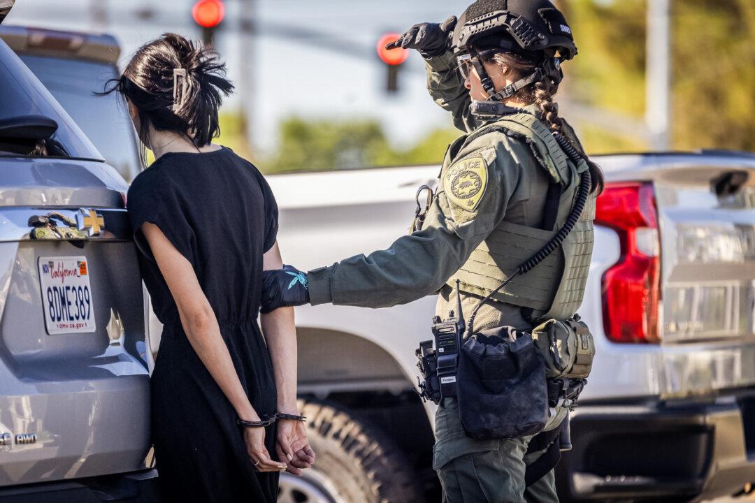 Police officers arrest people while raiding an illegal cannabis site in Lancaster, Calif., on Aug. 14, 2024. (John Fredricks/The Epoch Times)