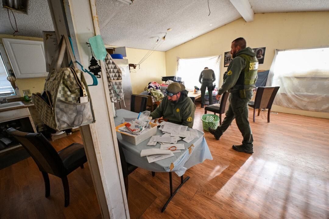 San Bernardino County Sheriff's deputies review documents inside a home during a raid of an illegal cannabis farm in Newberry Springs, Calif., on March 29, 2024. (Robyn Beck/AFP via Getty Images)