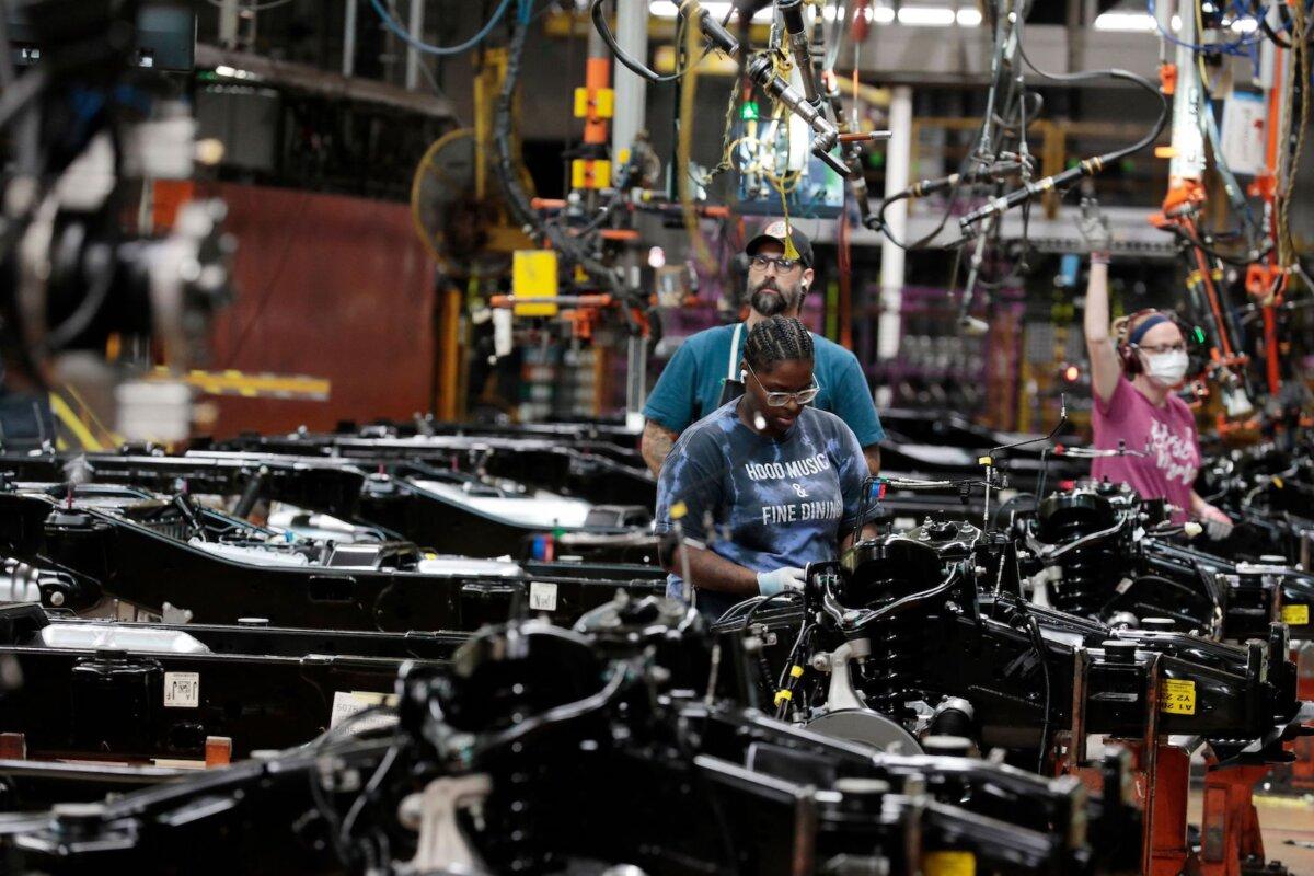 Workers put engines on the frame of Ford Motor Co. fuel-powered F-150 trucks under production at its truck plant in Dearborn, Mich., on Sept. 20, 2022. (Jeff Kowalsky/AFP via Getty Images)