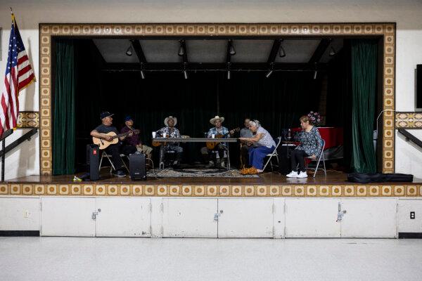 People sit at a table listening and playing music in Lincoln Heights Senior Center, which was turned into an augmented cooling center, as Southern California faces a heatwave, in Los Angeles on Sept. 4, 2024. (Etienne Laurent/AFP via Getty Images)