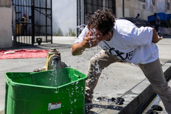 Omar, a homeless person, splashes his face with water from a bucket filled by an open fire hydrant as southern California faces a heatwave, in the Skid Row neighborhood of Los Angeles on Sept. 4, 2024. (Etienne Laurent/AFP via Getty Images)