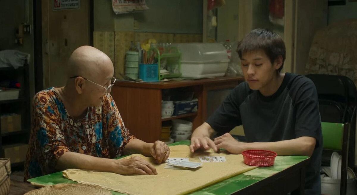Amah (Usha Seamkhum) plays a game with grandson M (Putthipong Assaratanakul), in “How to Make Millions Before Grandma Dies.” (GDH)