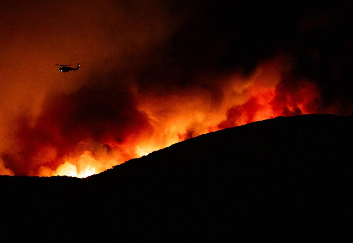 A helicopter flying above the Airport Fire near Trabuco Canyon, Calif., on Sep. 10, 2024. (John Fredricks/The Epoch Times)