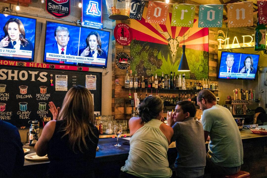 People sit behind a bar at a watch party for the presidential debate between Vice President Kamala Harris and former President Donald Trump at American Eat Co. in Tucson, Ariz., on Sept. 10, 2024. (Rebecca Noble/AFP via Getty Images)