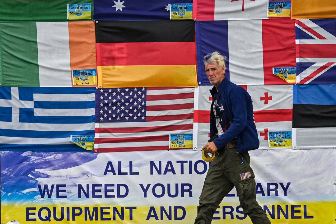 Ryan Wesley Routh sticks up national flags of the countries helping Ukraine, on Independence Square in Kyiv, Ukraine, on June 23, 2022. (Sergei Supinksy/AFP via Getty Images)