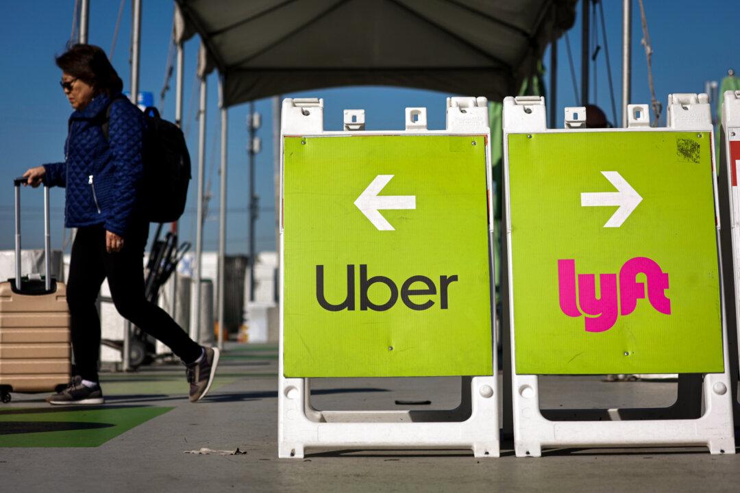 A traveler walks toward the Uber rideshare vehicle pickup area at the Los Angeles International Airport on Feb. 8, 2023. (Mario Tama/Getty Images)