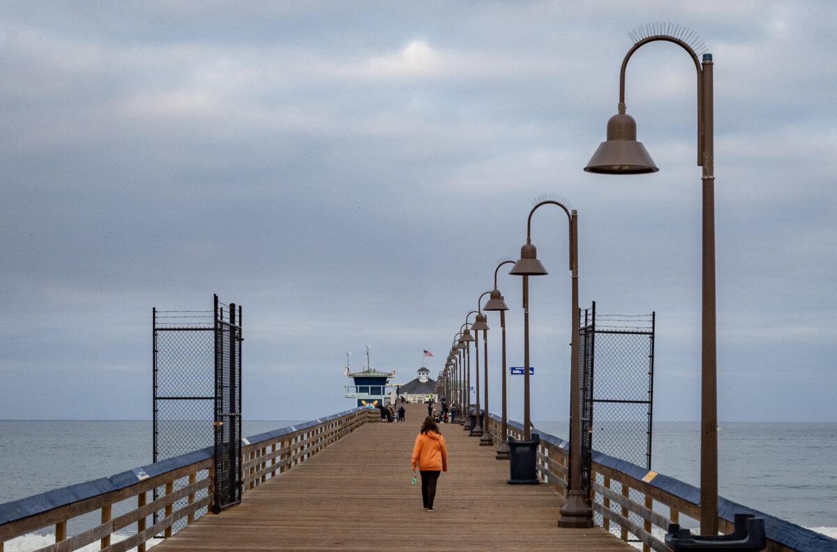 A woman walks along the Imperial Beach Pier in Imperial Beach, Calif., on Sept. 19, 2024. (John Fredricks/The Epoch Times)