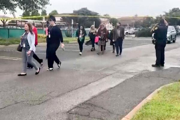 People walk past police following an explosion at the Santa Maria Courthouse in Santa Maria, Calif., on Sept. 25, 2024. (KEYT via AP)