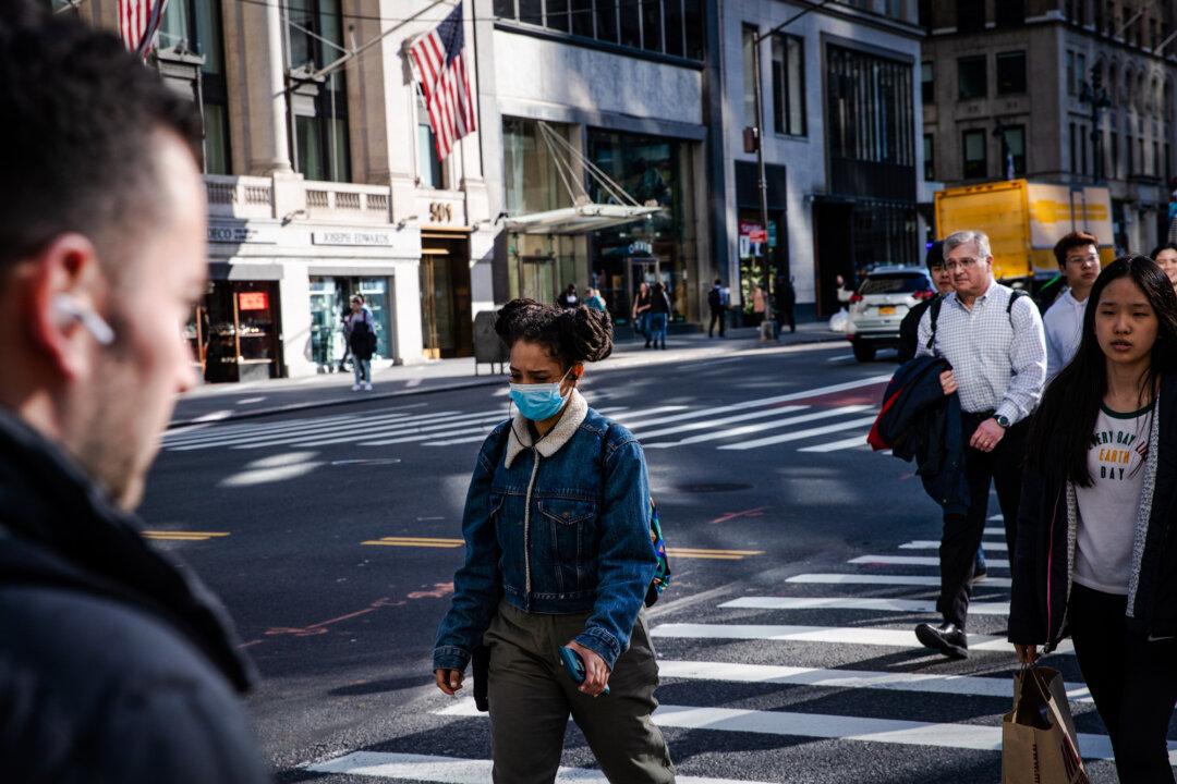 A woman wearing a mask walks on the street during the pandemic lockdowns, in New York City on March 13, 2020. (Jeenah Moon/Getty Images)