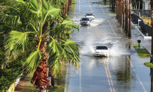 Vehicles drive through a flooded street as Hurricane Helene churns offshore in St. Pete Beach, Fla., on Sept. 26, 2024. (Photo by Joe Raedle/Getty Images)