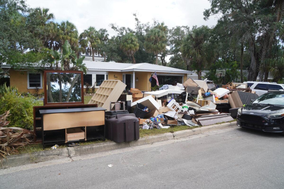 Debris piles up in front of Aubree and Austin Figler’s home on Sept. 29, 2024, after it endured more than three feet of flooding during Hurricane Helene. (T.J. Muscaro/The Epoch Times)