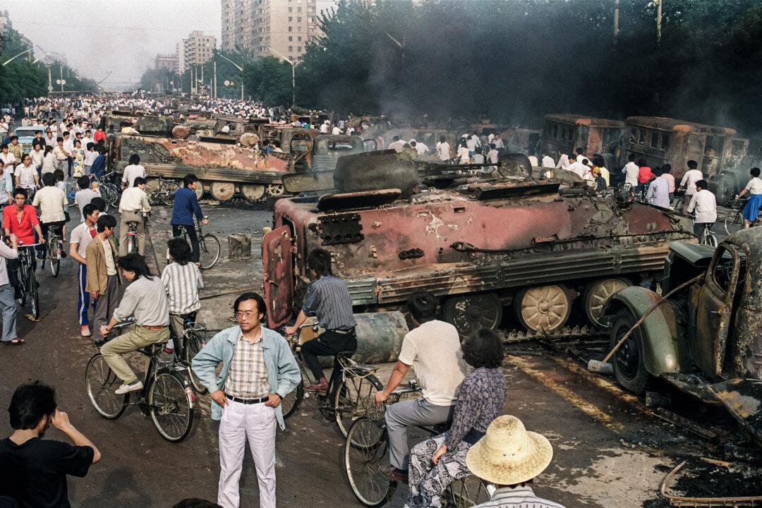 Beijing residents inspect the interior of one of over 20 armoured personnel carrier burnt by demonstrators to prevent the troops from moving into Tiananmen Square 04 June 1989. (MANUEL CENETA/AFP via Getty Images)