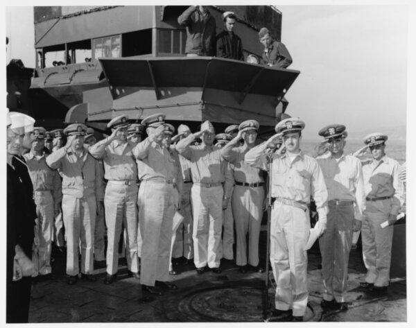 Officers salute as the U.S. national anthem is played during recommissioning ceremonies on the Stewart's foredeck while she was moored in Hiro Wan, Japan, on Oct. 29, 1945. Her new commanding officer, Lt. Cmdr. Harold H. Ellison, is standing by the microphone in the right-center foreground. (Official U.S. Navy photograph, now at the National Archives)