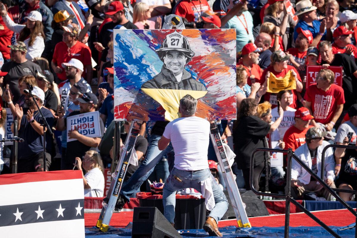 Artist Scott Lobaido unveils his artwork of Corey Comperatore at a rally with former President Donald J. Trump at Butler Farm Show in Butler, Pa., on Oct. 5, 2024. (Samira Bouaou/The Epoch Times)