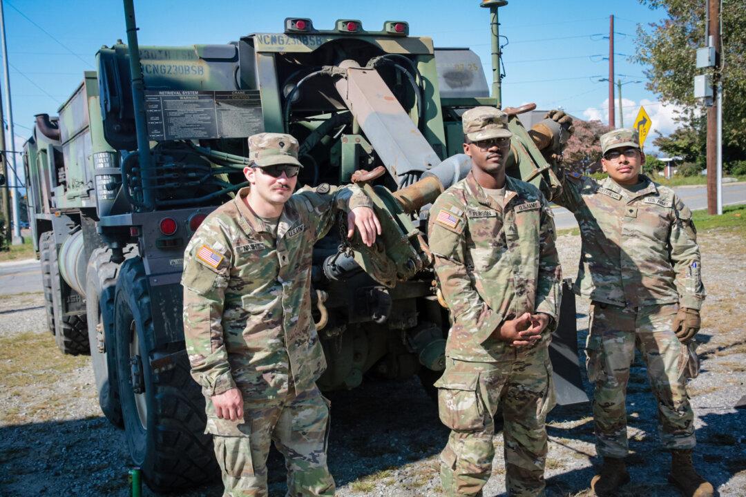 North Carolina Army National Guard Spc. Paxton Nash (L), Sgt. Maurice Person (C), and Spc. Ian Castaneda (R) of the 875th Engineers Company, have orders to support disaster relief in the Asheville, N.C., area, on Oct. 3, 2024. (Richard Moore/The Epoch Times)