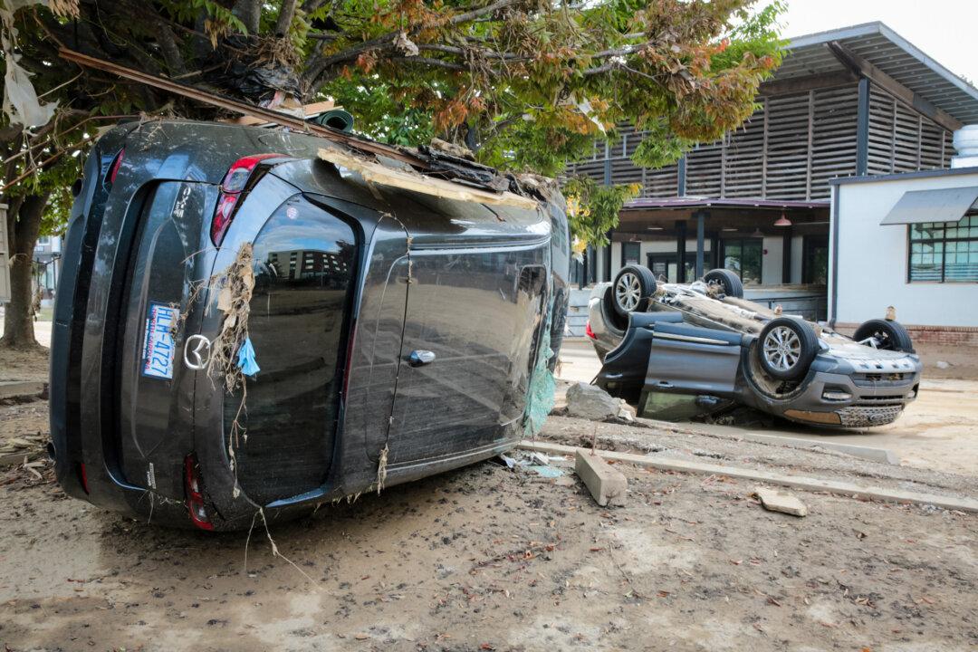 Overturned cars near a railway line in Biltmore Village, N.C., on Oct. 3, 2024. (Richard Moore/The Epoch Times)