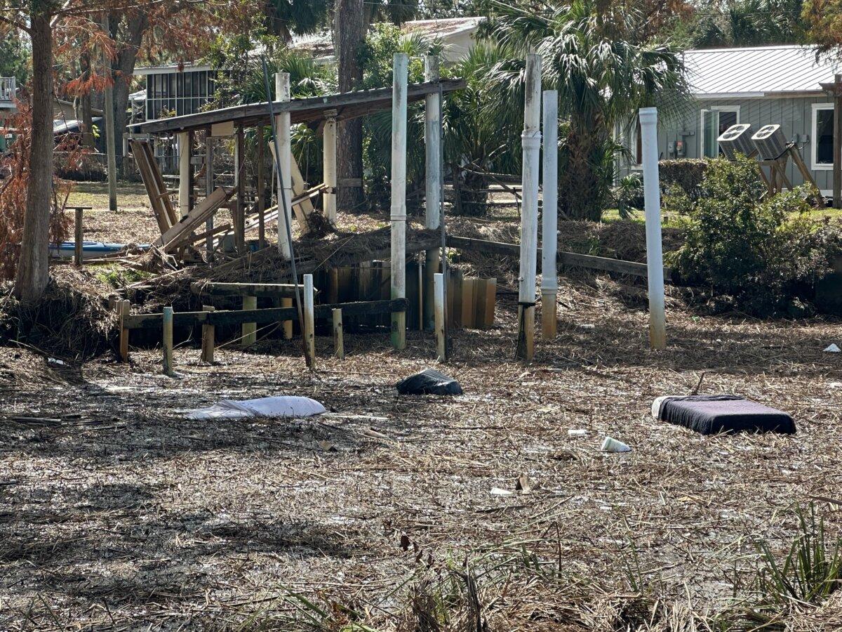 A still-made bed floats in a debris-covered canal next to homes destroyed by Hurricane Helene in Suwannee, Fla., on Oct. 5, 2024. (Nanette Holt/The Epoch Times)