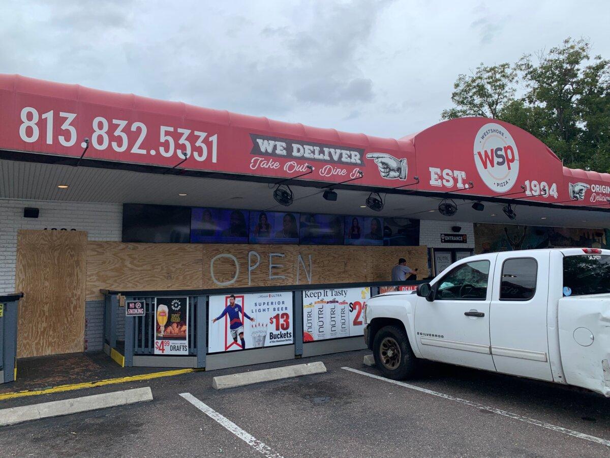 Westshore Pizza, one of the few restaurants in South Tampa to partially reopen after Hurricane Helene, serves carry-out customers on Oct. 8, 2024. (T.J. Muscaro/The Epoch Times)