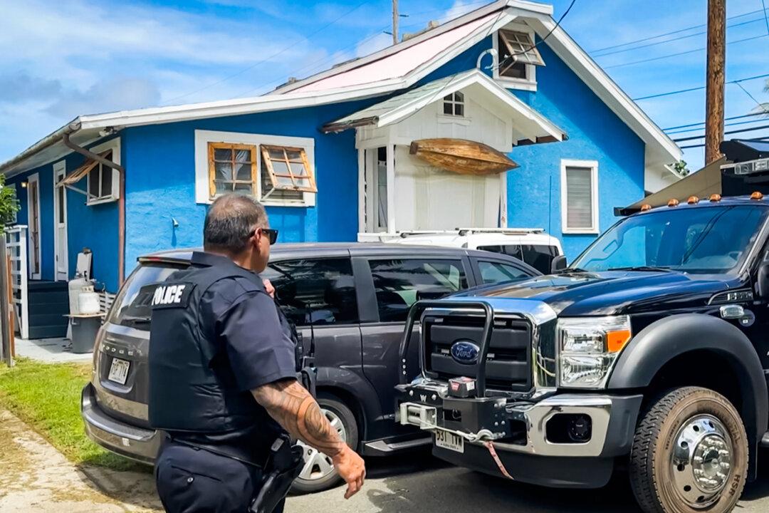 A police officer walks near Ryan Routh's home while FBI agents conduct a search inside, in Kaaawa, Hawaii, on Sept. 17, 2024. (Audrey McAvoy/AP Photo)