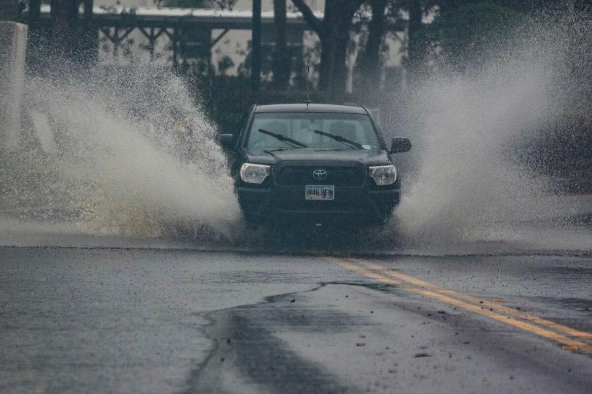 Vehicles move through a partially flooded street in Dunedin ahead of Hurricane Milton's expected landfall tonight Oct. 9, 2024 in Florida. (Bryan R. SMITH /AFP via Getty Images)