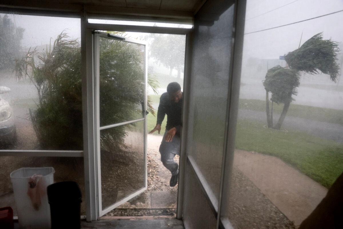 Chris Williams runs through a rain storm as he packs his car to evacuate his apartment before Hurricane Milton's arrival in Fort Myers, Fla., on Oct. 9, 2024. (Joe Raedle/Getty Images)