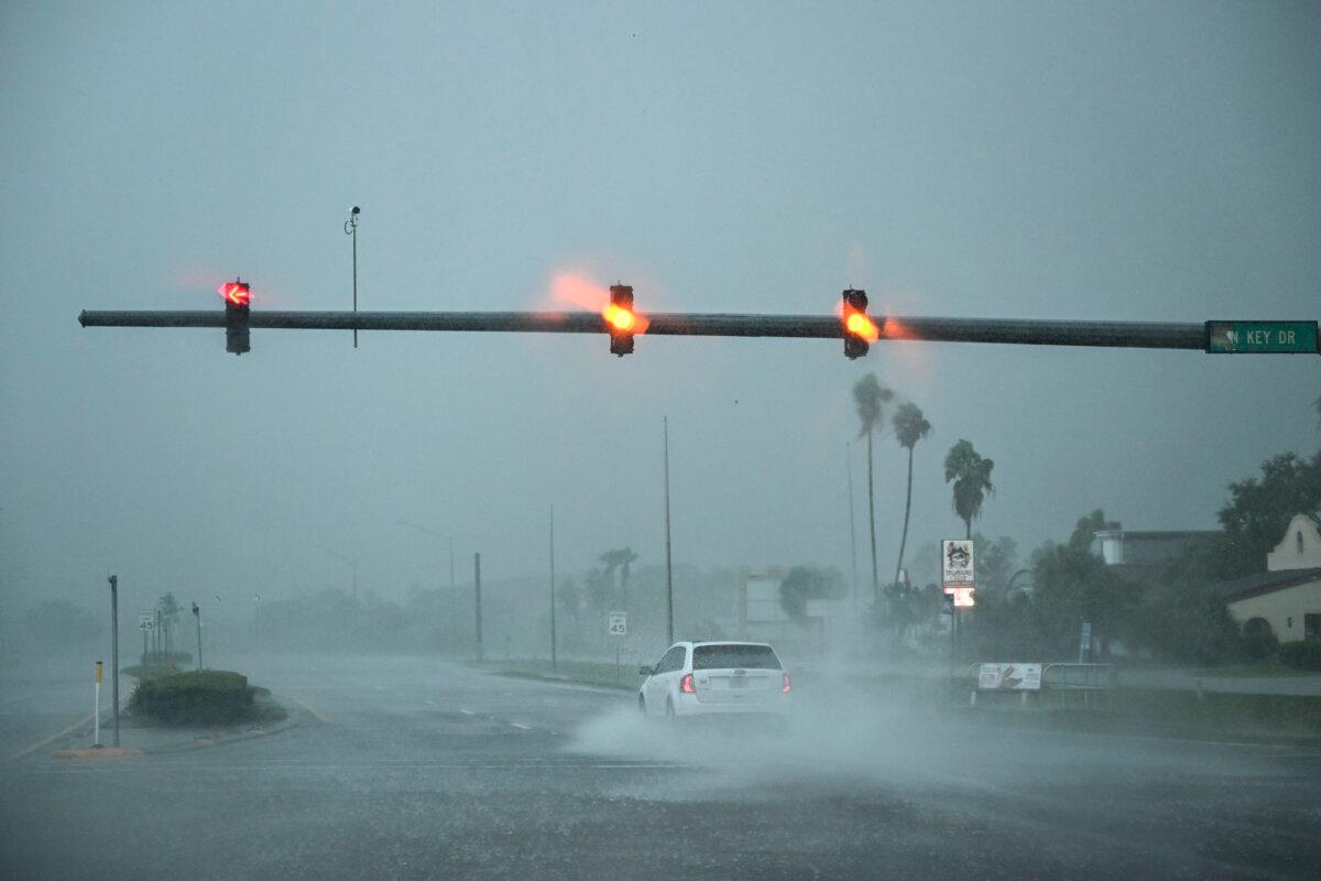 A car drives through the heavy rain in Fort Myers, Fla., on Oct. 9, 2024 as Hurricane Milton approaches. (Chandan Khanna/AFP via Getty Images)