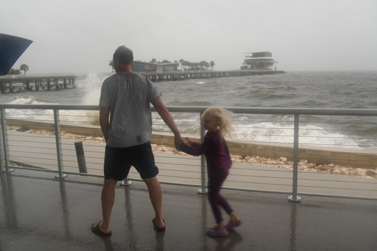 Dennis Kraus shows his children waves crash along St. Pete Pier in St. Petersburg as Hurricane Milton is expected to make landfall tonight on Oct. 9, 2024 in Florida. (Bryan R. Smith /AFP via Getty Images)