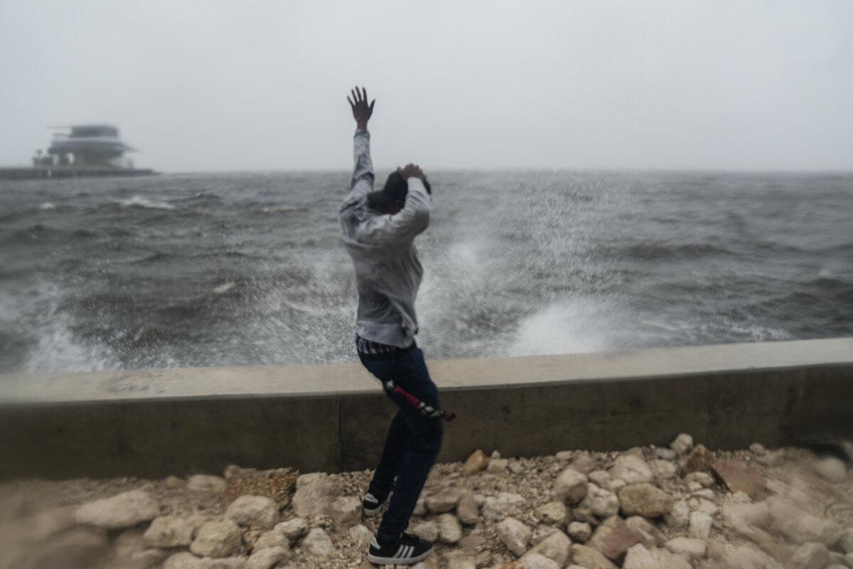 Jeremy Beal of St. Petersburg reacts as waves crash along St. Pete Pier in St. Petersburg, Florida, as Hurricane Milton is expected to make landfall tonight on Oct. 9, 2024. (Bryan R. Smith /AFP via Getty Images)