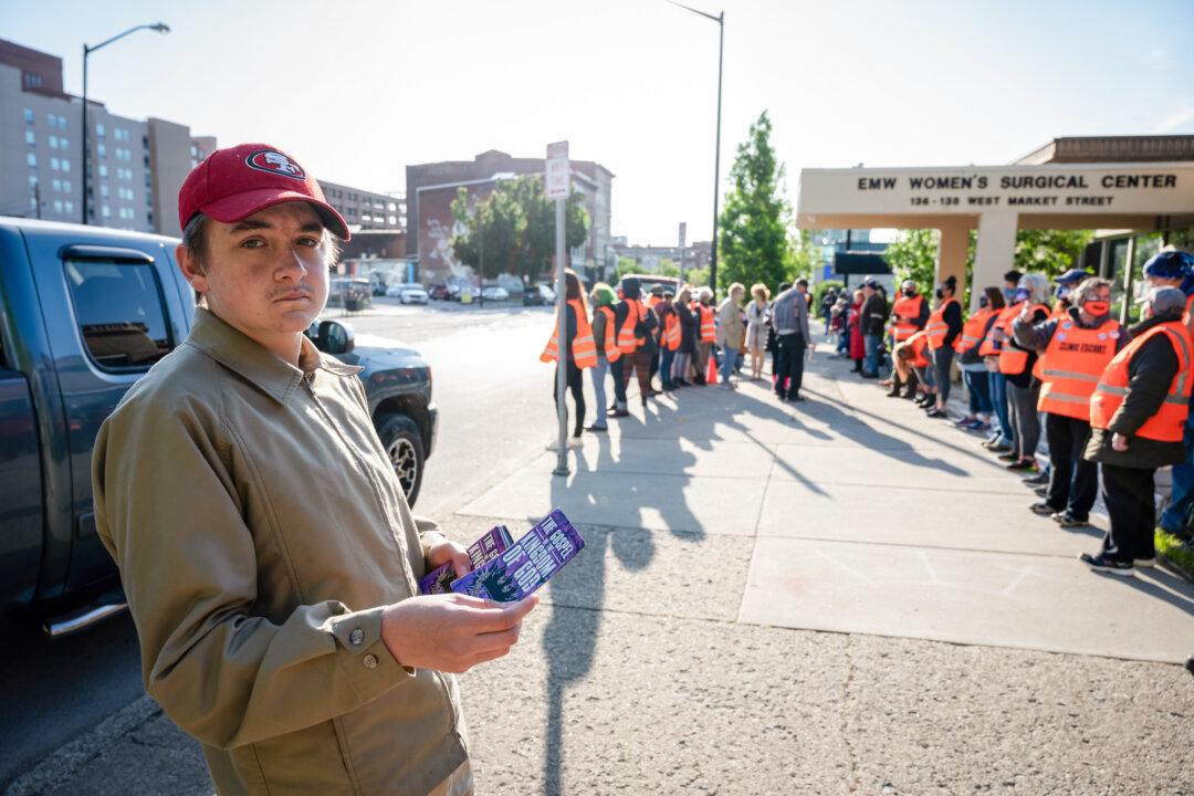 A pro-life demonstrator distributes an information pamphlet in front of the EMW Women's Surgical Center, an abortion clinic, in Louisville, Ky., on May 8, 2021. (Jon Cherry/Getty Images)