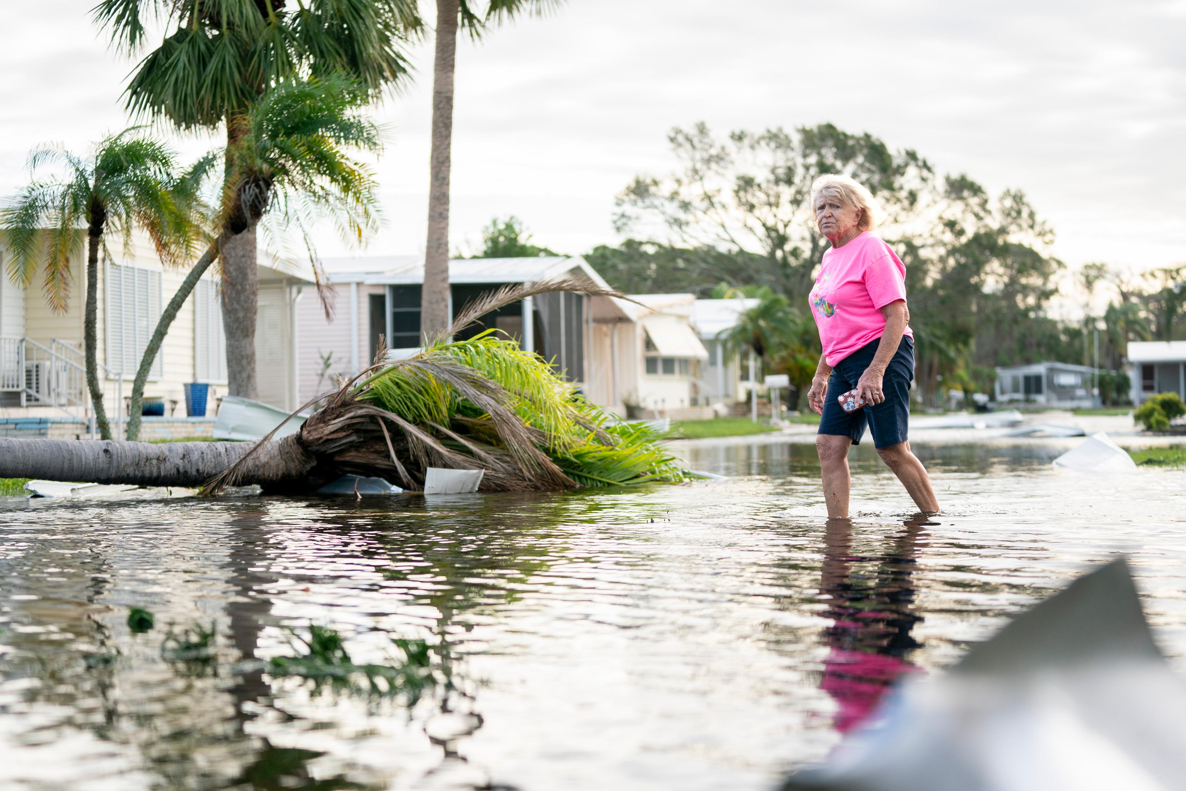 A woman walks along a flooded street in the aftermath of Hurricane Milton in Osprey, Fla., on on Oct. 10, 2024. (Sean Rayford/Getty Images)