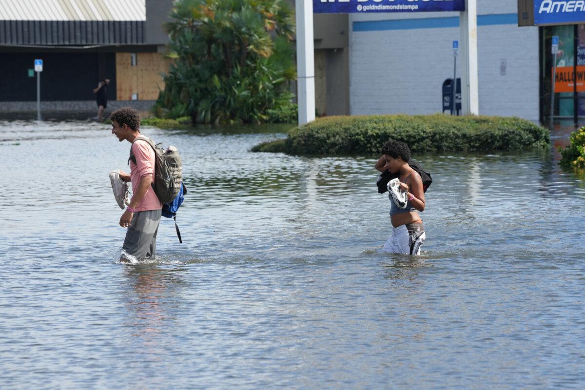 People walk through flooded streets in the Southeast Seminole Heights section of Tampa due to Hurricane Milton in Florida on Oct. 10, 2024. (Bryan R. Smith/AFP via Getty Images)