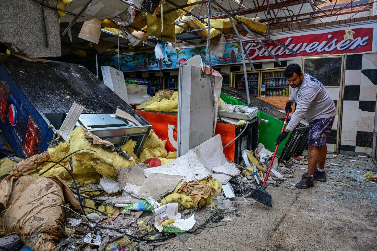 A man cleans debris inside a gas station store in Lakewood Park, Florida, after a tornado hit the area and caused severe damage as Hurricane Milton swept through Florida on Oct. 10, 2024. (Giorgio Viera/AFP via Getty Images)