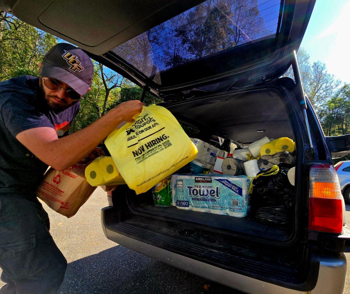 Nick George unloads items from his car to support Hurricane Helene survivors at Stone Mountain Baptist Church in Black Mountain, N.C., on Oct. 8, 2024. (Allan Stein/The Epoch Times)