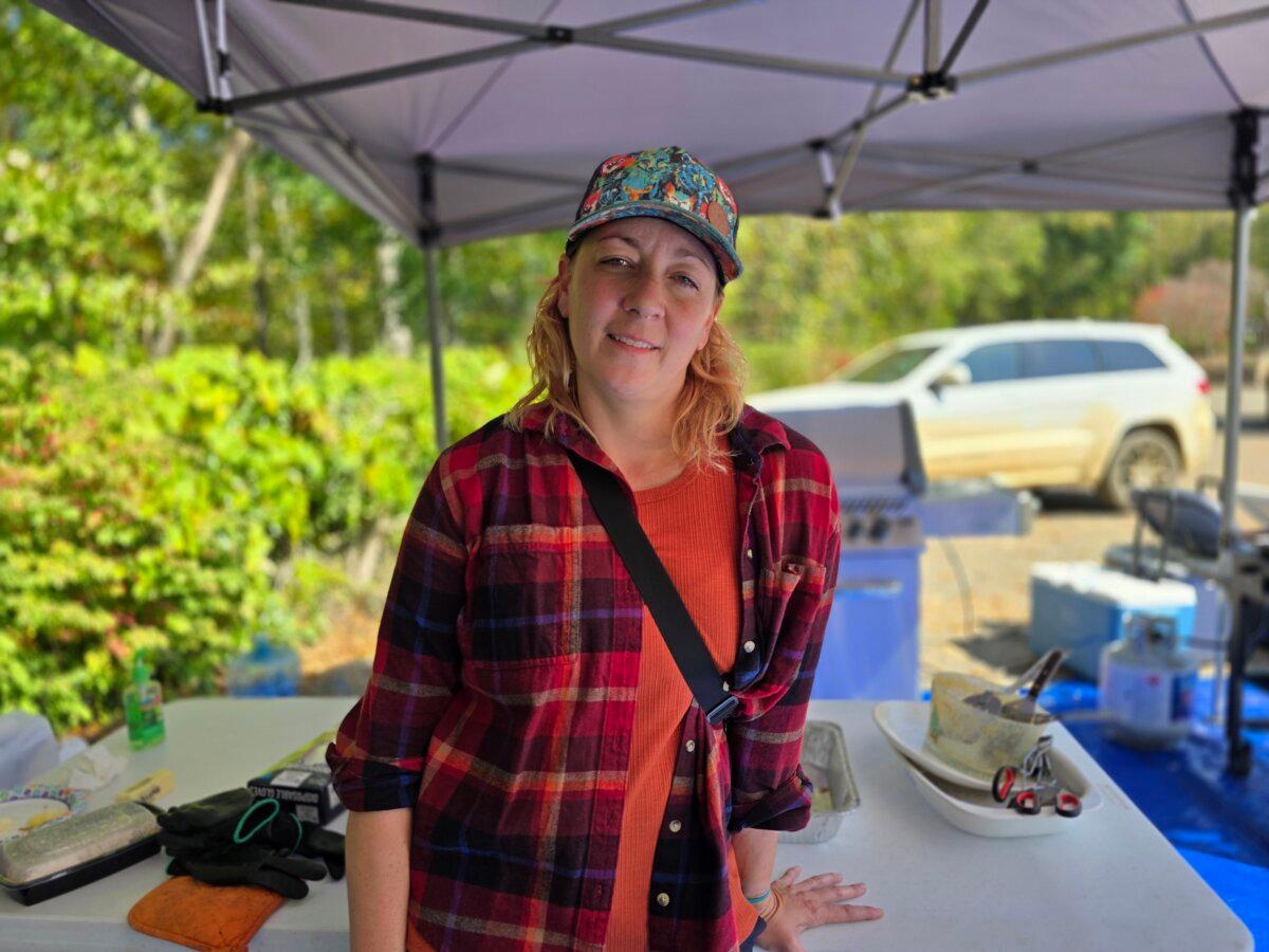 Volunteer Natalie Wolfe helps with food distribution at the Nesbitt Church in Fairview, N.C., on Oct. 8, 2024. (Allan Stein/The Epoch Times)