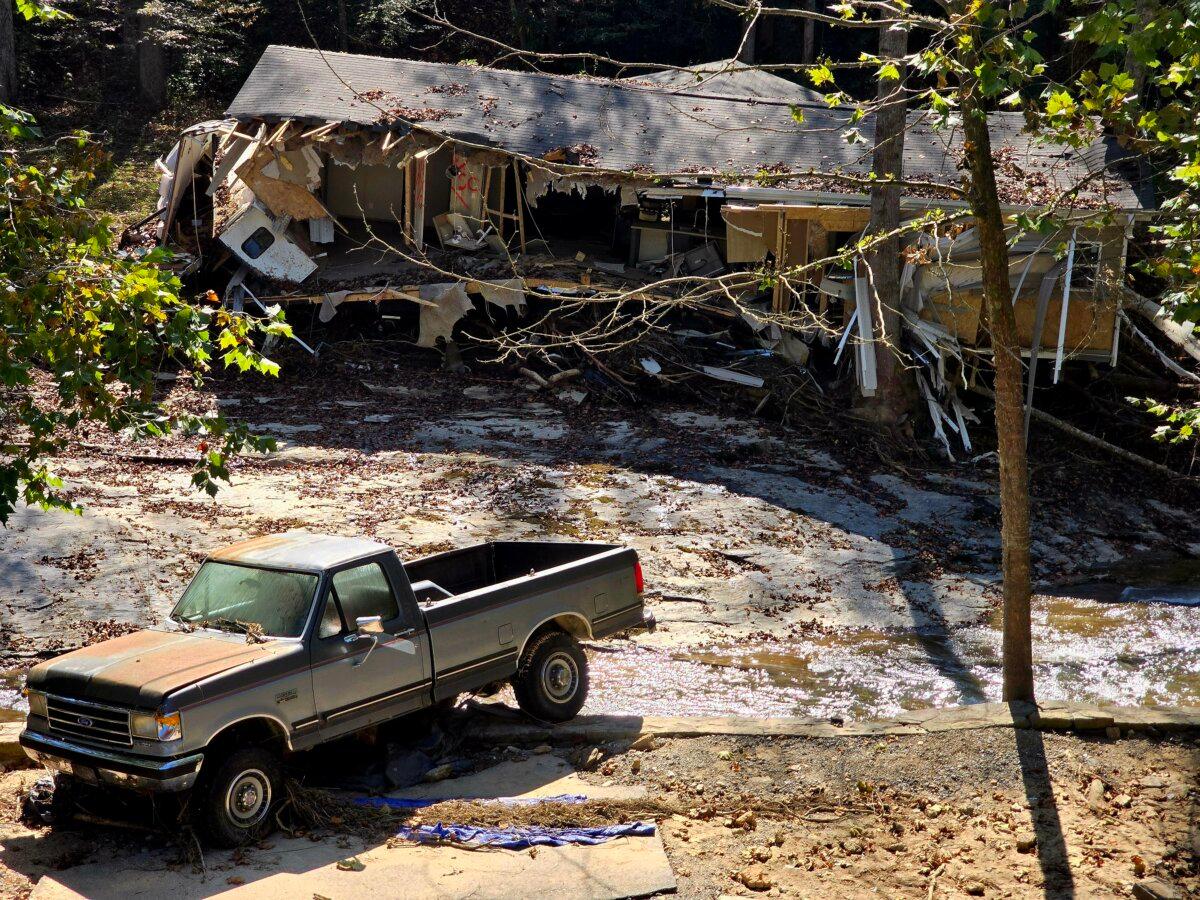 A demolished house and a damaged pickup truck were all that remained in a flood-ravaged area near Asheville, N.C., on Oct. 8, 2024. (Allan Stein/The Epoch Times)