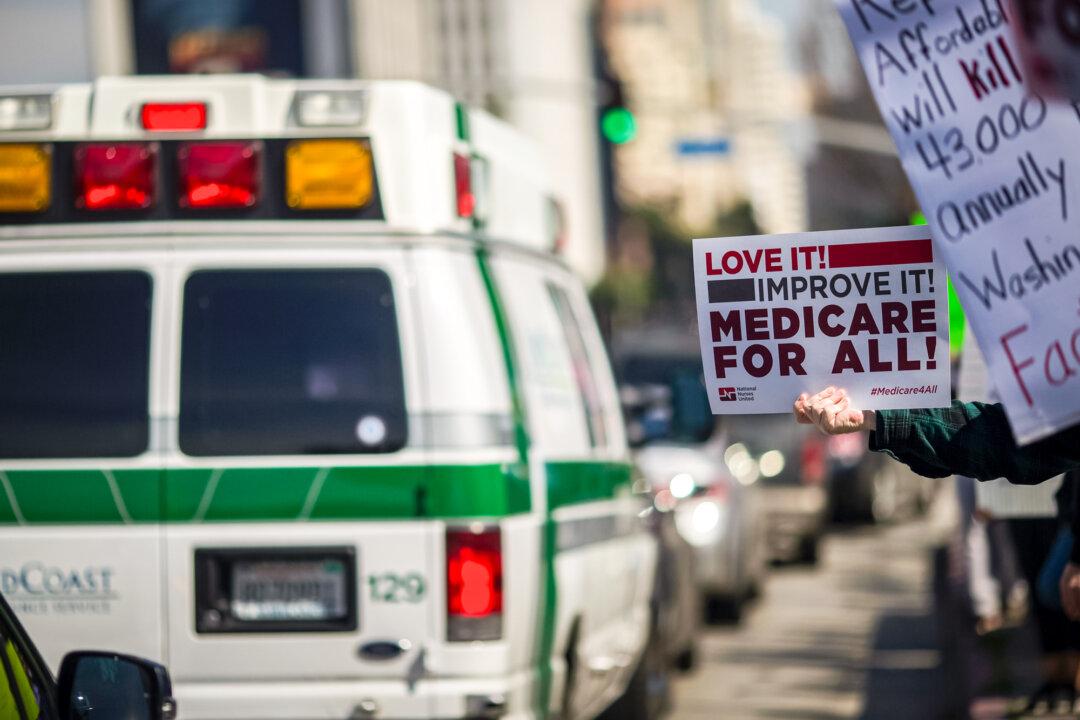 An ambulance drives past protesters supporting the Affordable Care Act near the Wilshire Federal Building in Los Angeles on Jan. 25, 2017. (David McNew/AFP via Getty Images)