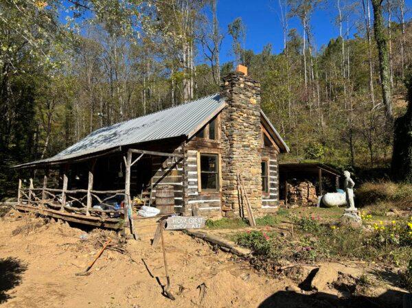 A man who lives in a 19th century cabin in the western North Carolina mountains receives assistance from a volunteer group at Camp Unknown on Oct. 17, 2024. (Jeff Louderback/The Epoch Times)