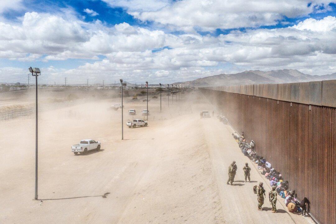 Illegal immigrants wait to be processed after crossing the Rio Grande river into the United States, in El Paso, Texas, on March 25, 2024. (Brandon Bell/Getty Images)