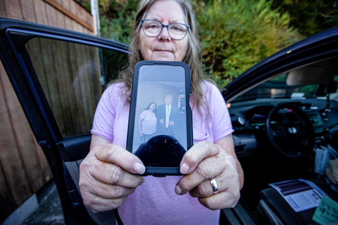 Nancy Randolph shows a picture on her phone of her standing next to a cut-out of former President Donald Trump, in Spruce Pine, N.C., on Oct. 21, 2024. (Bobby Sanchez/The Epoch Times)