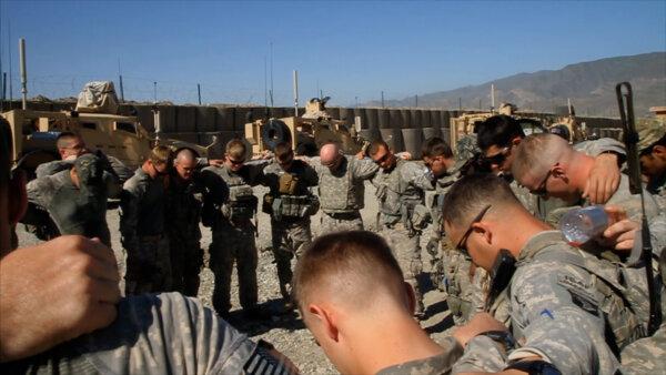 U.S. soldiers gather to take part in a prayer circle. (Paulist Productions)