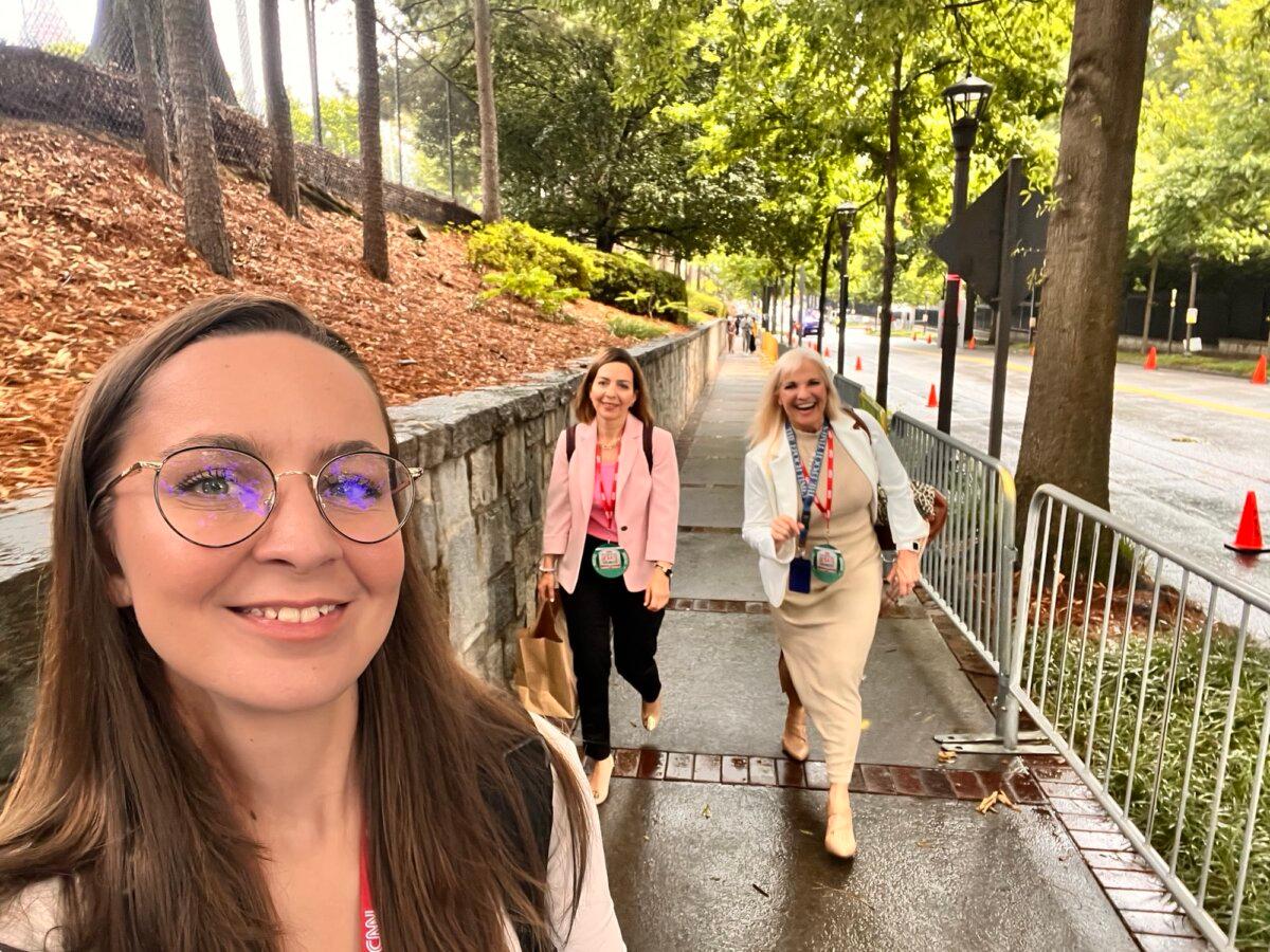 Epoch Times photographer Madalina Vasiliu (L) snaps a selfie as Epoch Times reporters Emel Akan (C), and Janice Hisle (R) make their way toward the venue for the presidential debate between President Joe Biden and former President Donald Trump in Atlanta on June 27, 2024 (Madalina Vasiliu/The Epoch Times)