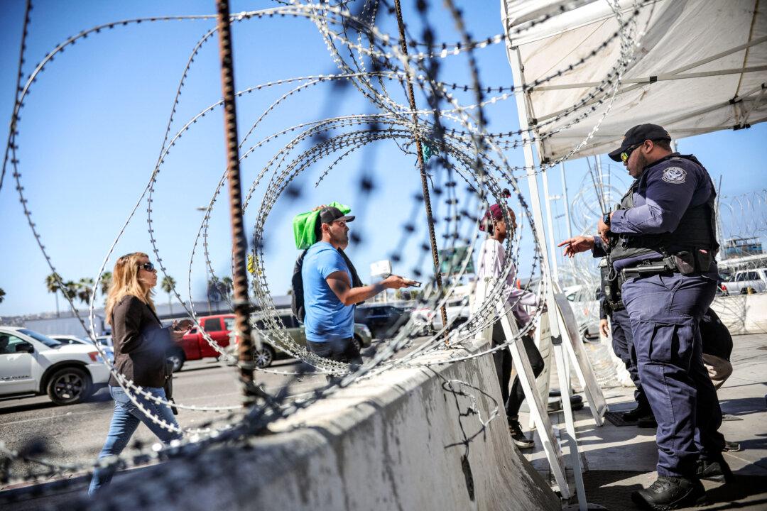 A U.S. Customs and Border Protection agent checks documentation at the San Ysidro Port of Entry in San Ysidro, Calif., on Oct. 2, 2019. (Sandy Huffaker/AFP via Getty Images)