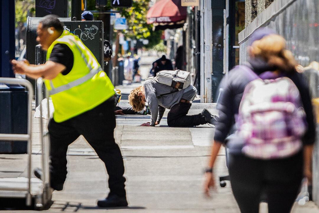 People use drugs in the Tenderloin District of San Francisco on May 16, 2024. (John Fredricks/The Epoch Times)