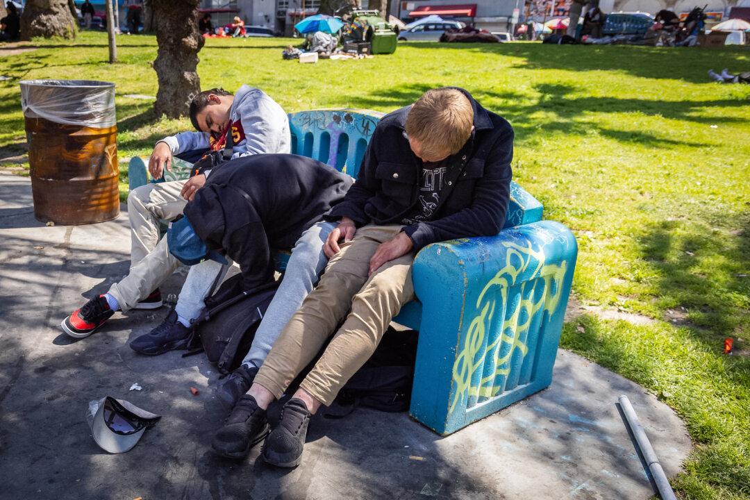 Men are passed out after using drugs in Los Angeles on April 10, 2024. (John Fredricks/The Epoch Times)